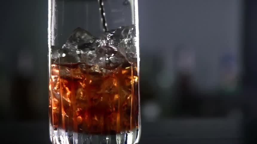 A beverage with crushed ice is being stirred