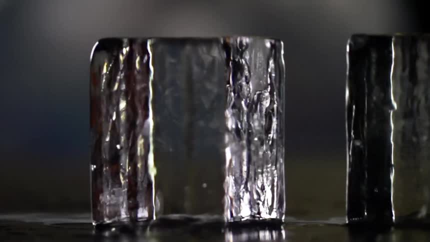 A person sliding two ice cubes together to make them collide