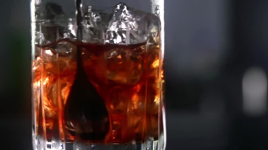 A spoon is stirring an alcoholic drink