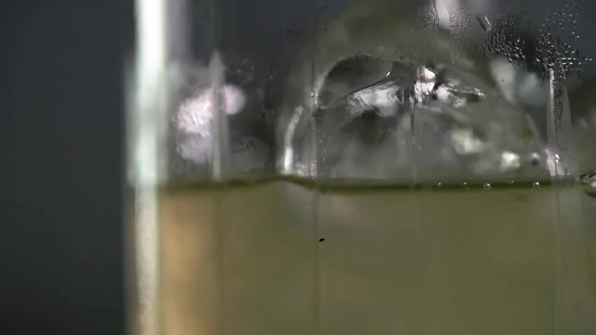 A glass of cocktail is topped off