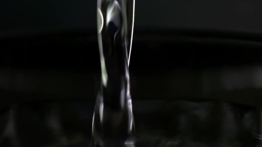 White wine pours from a glass jar