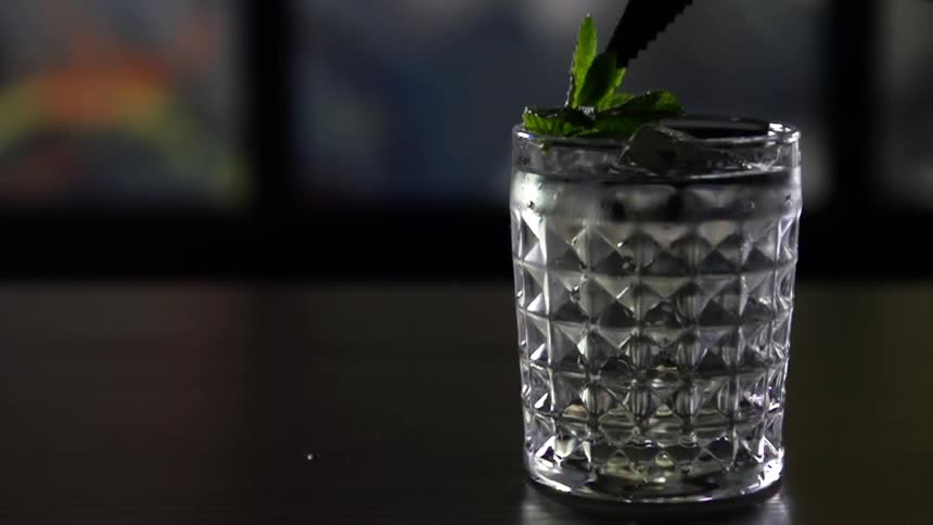 A mint leaf is placed in a drink