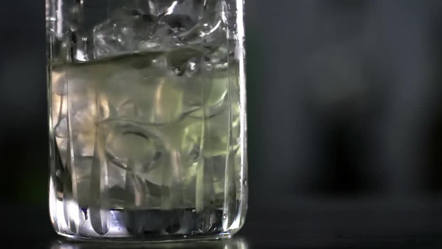 A cocktail being stirred with ice cubes