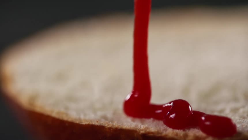 Ketchup pouring over  a bun