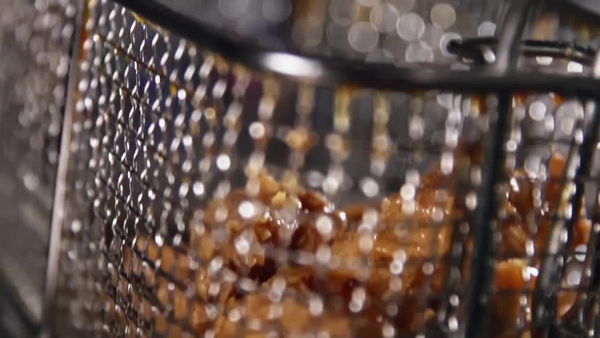 Food being lifted out of a deep fryer