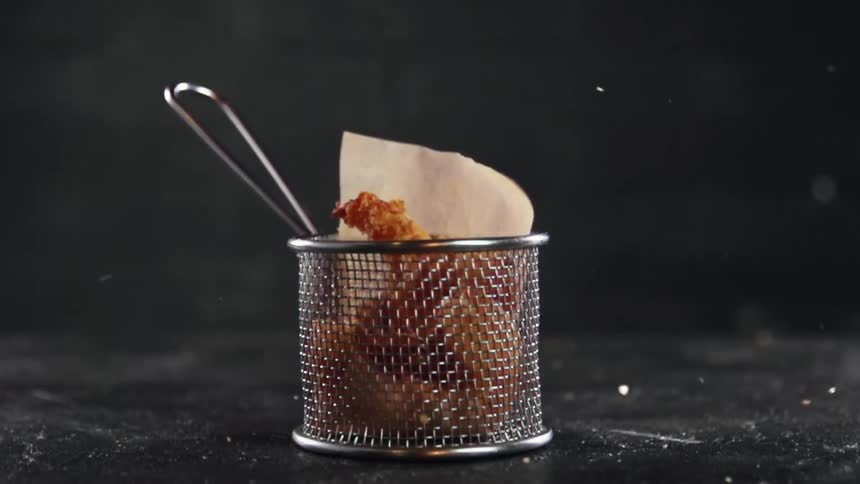 Crispy coated shrimp falls into a mesh basket