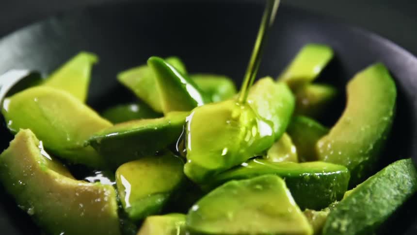 A bowl full of avocado drizzled in oil