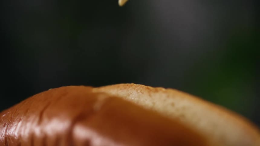 A hot dog bun has mustard drizzled into it