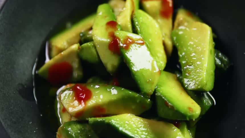 Lime juice falling on to chopped avocados