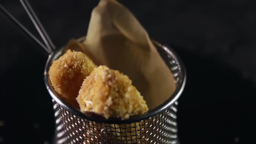Chicken nuggets being placed in a basket