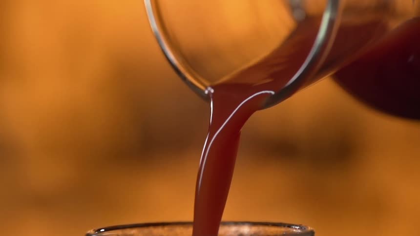 Liquid being poured from a pitcher into a glass