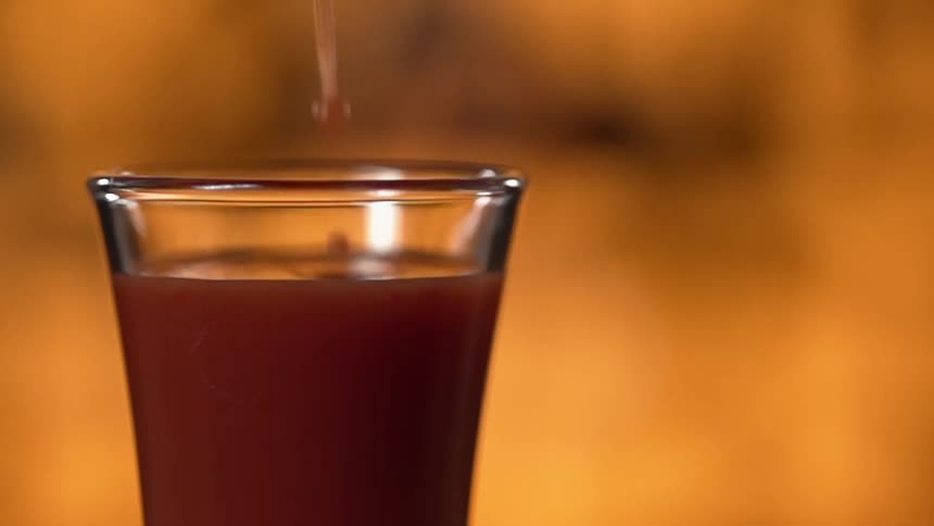 Red juice being poured into a glass