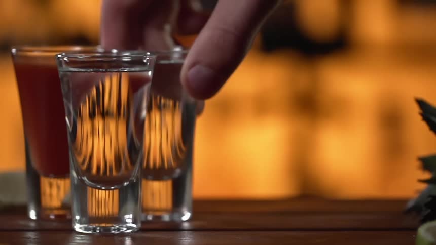 A person places a shot on the counter