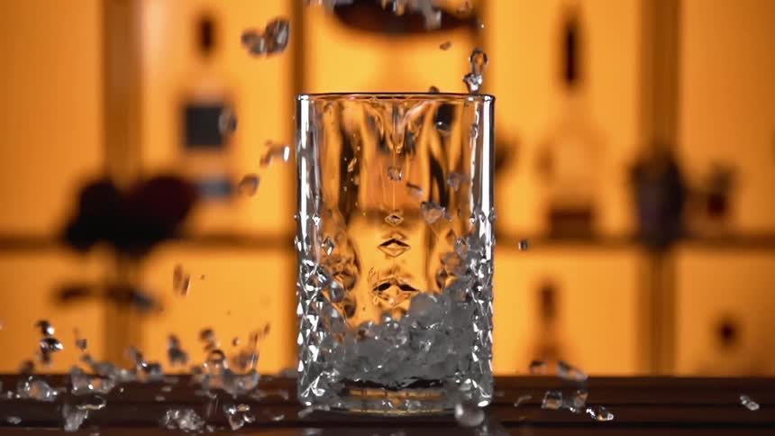 Ice cubes are being dropped on the table in a bar