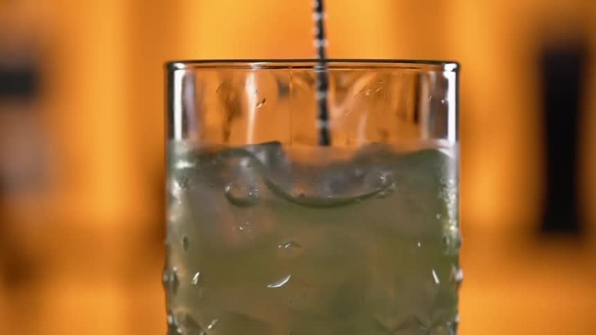 Mojito with ice in a clear stirred with a spoon