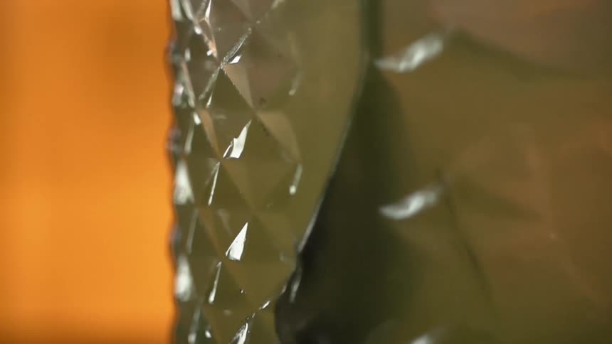 The contents of a glass of liquor with ice continue to swirl around