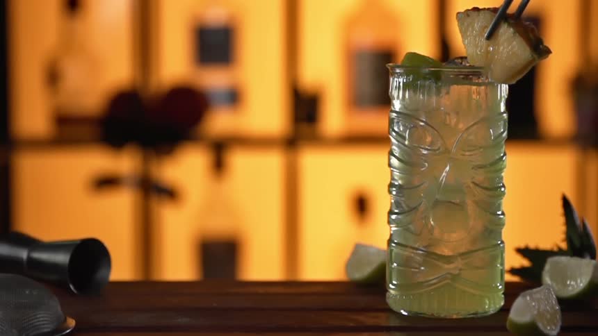 Pineapple being placed on rim of a cocktail glass