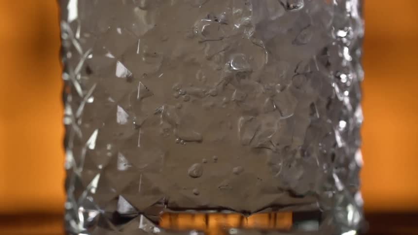 Close up of a glass of liquid with ice cubes