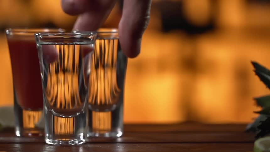 A shot being picked up from bar counter
