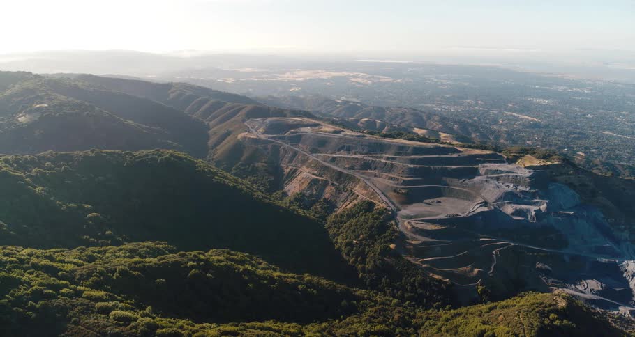 Roads carved onto one peak of a mountain ridge covered in vegetation