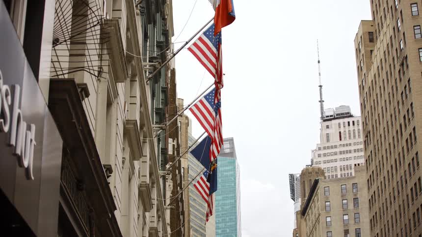 Flags on the side of a building in a downtown area