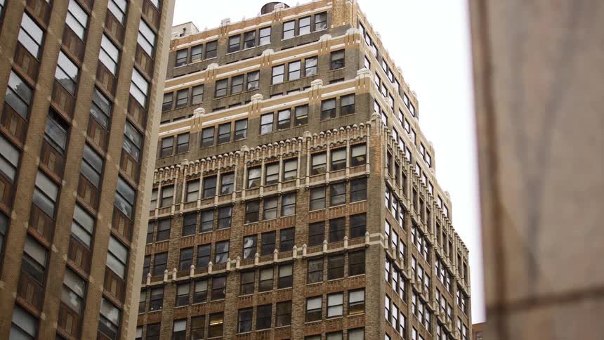 Tall brown and gray buildings in a metropolis during the day