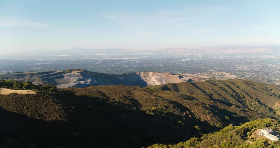 Mountains and hills sit under a sunny blue sky