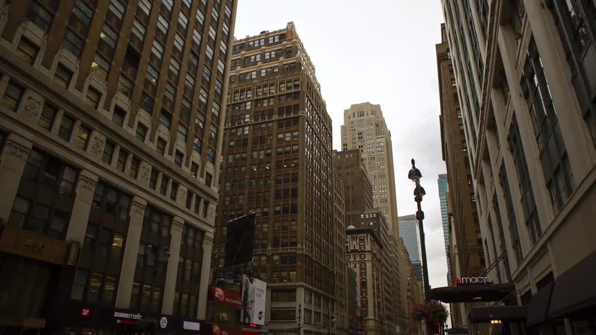 City street with tall buildings and shops in downtown on a cloudy day