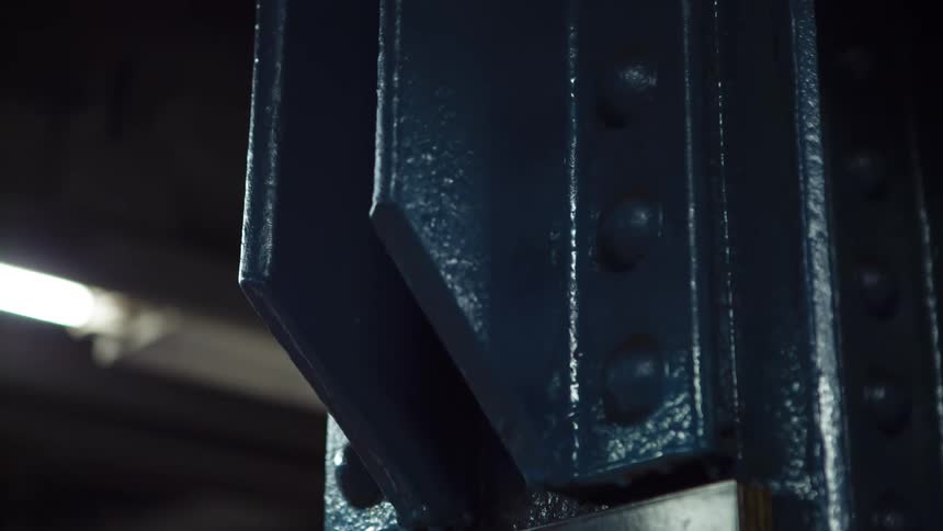 A piece of machinery painted blue sits inside a shop