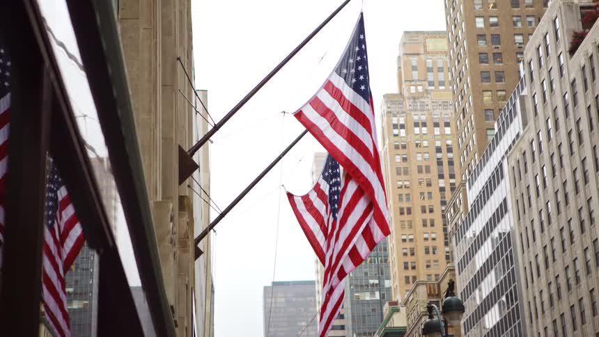 American flag hangs from the pole in the city