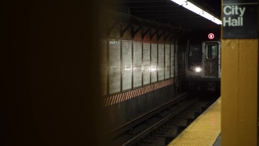 Subway train carrying people arrives at underground station