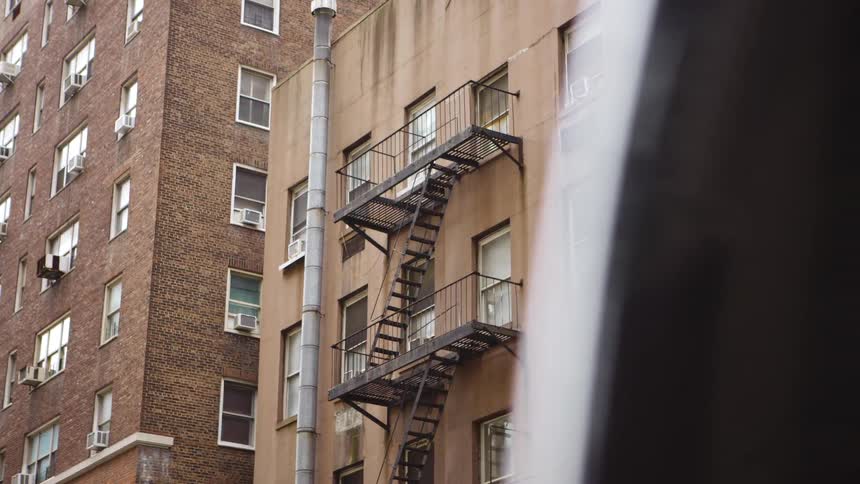 City apartments and a building with fire escape mounted to the outside of the building
