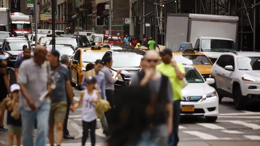 Pedestrians crossing the street in a busy intersection in new york city
