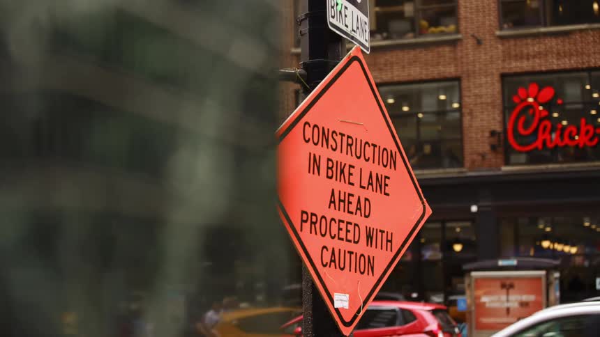 Cars drive past the busy city street