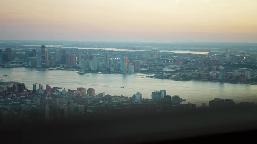 A boat moves on a river by a large city