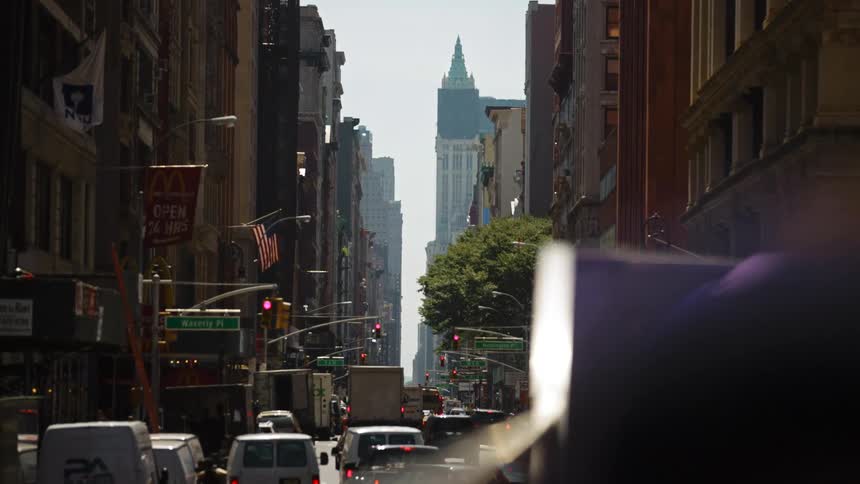 A busy street surrounded by tall buildings in a metropolis during the day