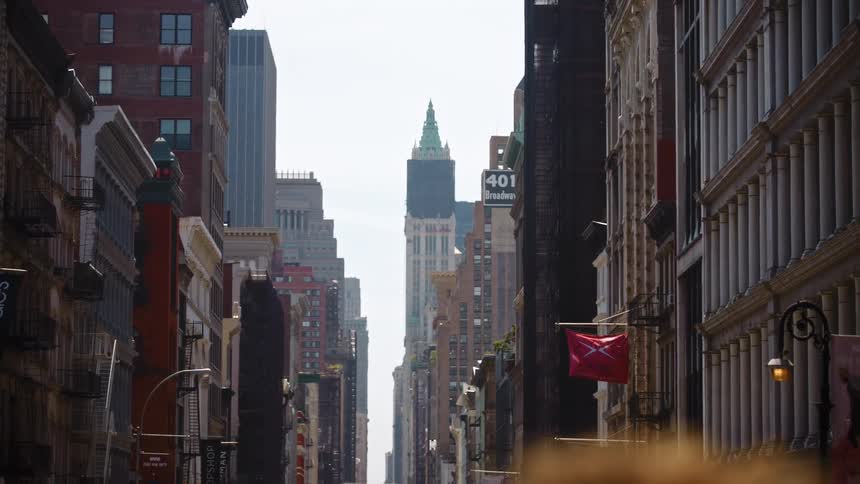 A city block is lined with tall apartment buildings and skyscrapers