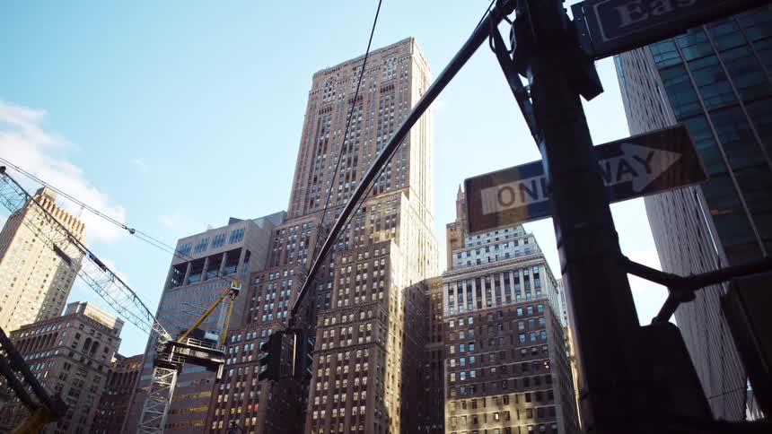 Construction equipment sits in front of a high rise building near an intersection