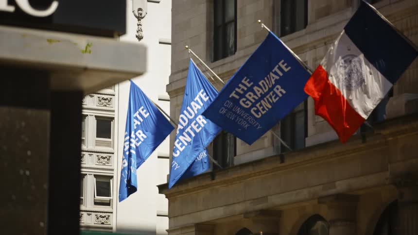 A row of flags mounted on the facade of a building in a metropolis wave in the wind