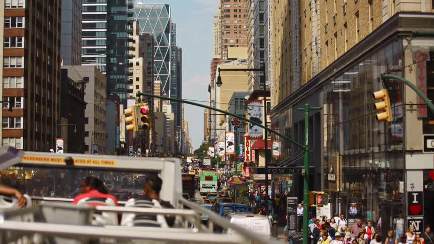 People and vehicles on a busy city street with shops and office buildings
