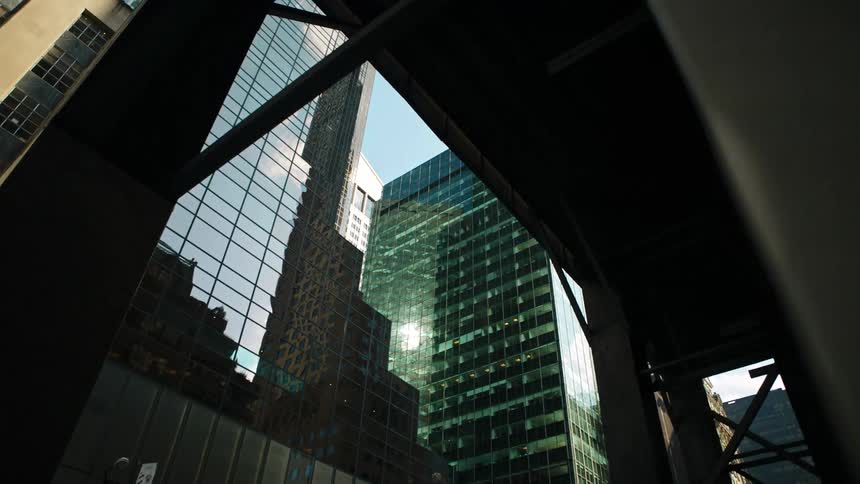 An elevated train platform runs next to tall skyscrapers in a city