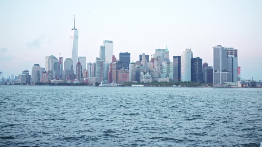 Big city skyline from a distant with multiple tall buildings seen from sea on the horizon