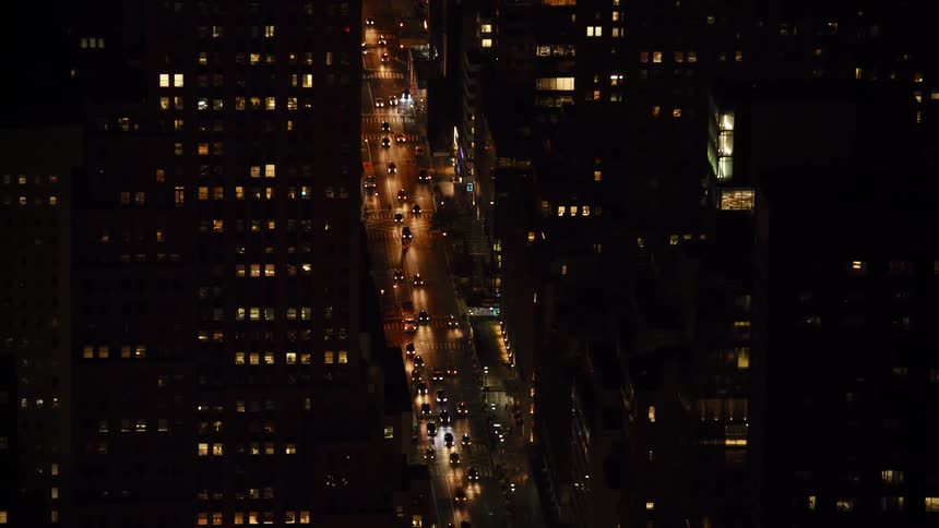 Vehicles travel on the city street at night