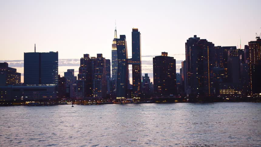 The skyscrapers and freeway on the coast of a metropolis bordering the ocean at sunset