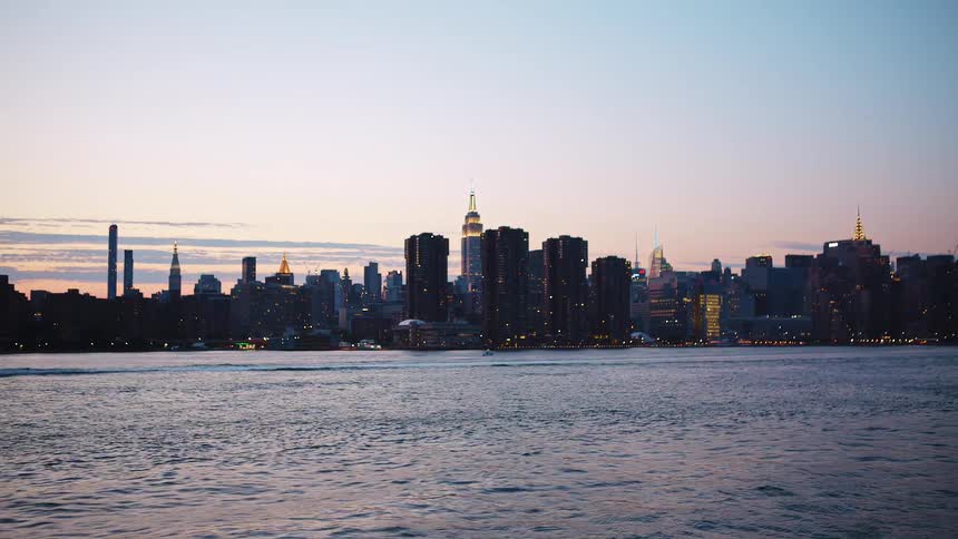 A coastal city with water and boats with the city skyline with buildings and skyscrapers in the background