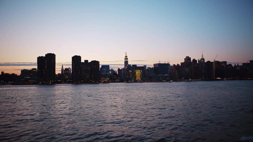The sun is setting over the city past the water