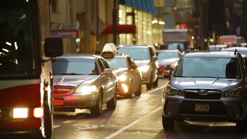 Traffic moves along a busy street in a metropolis at night