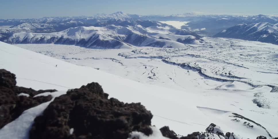 A skier in the distance with a huge vista beyond