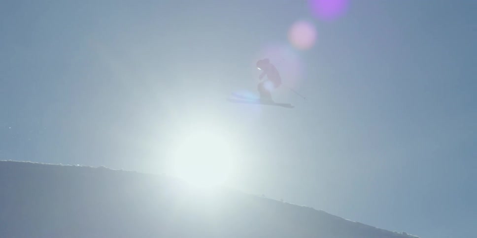 A person skiing does a jump through the sunand crashes