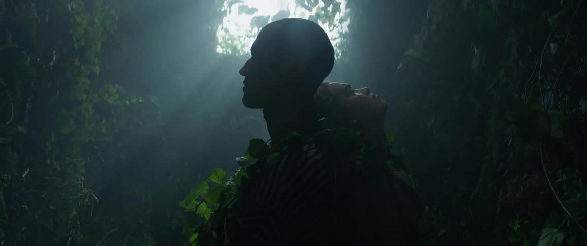 A man and woman are tied up with vines